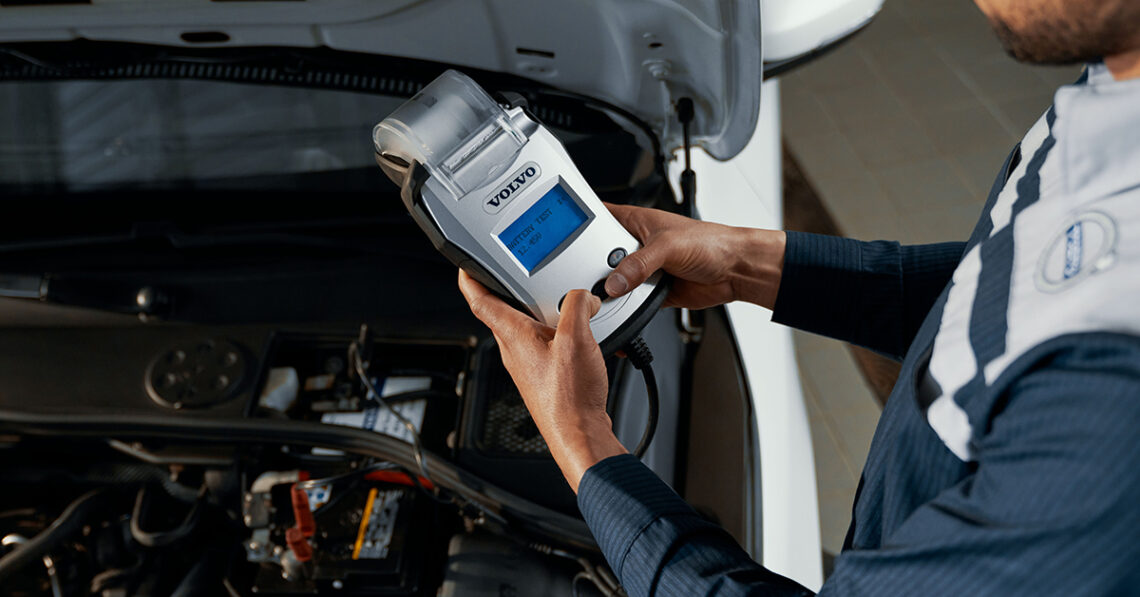 Volvo service technician inspecting a battery